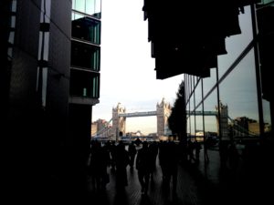 The Tower Bridge in London, viewed in the distance between two buildings